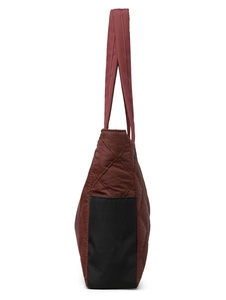 Detail view of burgundy quilted nylon tote bag with side pockets and a wide strap
