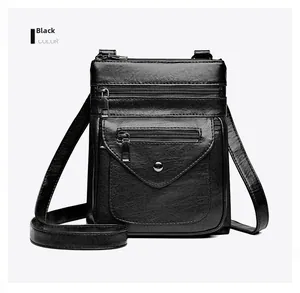 Detail view of black PU leather crossbody bag featuring three functional zipper pockets