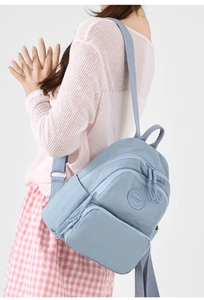 Side view of a light blue nylon backpack showing multiple storage pockets and large capacity