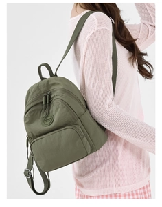 Side view of olive green nylon backpack showing large capacity and brand logo on model