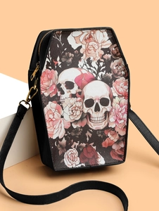 Detail of coffin-shaped crossbody bag featuring skull and pink rose gothic prints