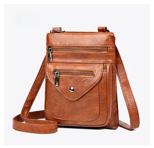 Detail view of brown vintage faux leather crossbody bag with multiple zip pockets