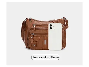 Brown PU leather crossbody bag with multi-zipper pockets compared to an iPhone for size