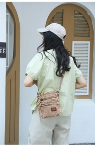 Three-layer light brown corduroy crossbody bag shown on model in minimalist setting