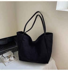 Détail d'un grand cabas en velours côtelé noir avec texture verticale et anses solides