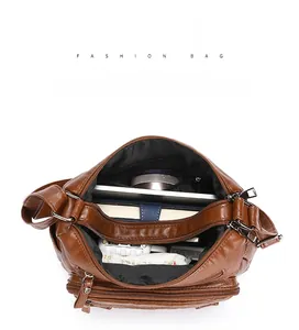 Detailed interior of a brown faux leather crossbody bag showing large storage capacity