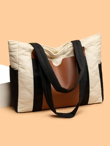 Detail of quilted nylon tote bag with leather patchwork and adjustable wide shoulder strap