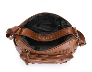 Detailed top view of brown leather crossbody bag with multiple zipper compartments