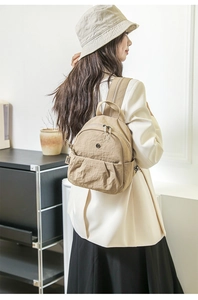 Detail von khakifarbenem wasserfestem Nylon-Rucksack und Fischerhut am Modell