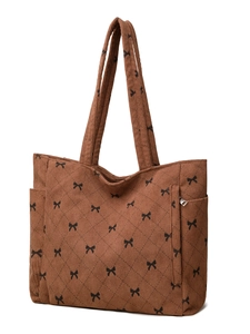 Detail view of brown corduroy tote bag showing quilted texture and side zipper pocket