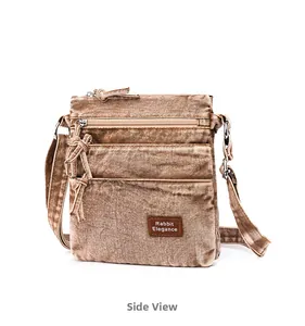 Detailed side view of the brown washed canvas crossbody bag with multiple zip compartments