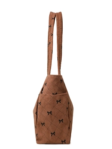 Detail of dark brown corduroy tote bag with bow print and diamond quilted texture