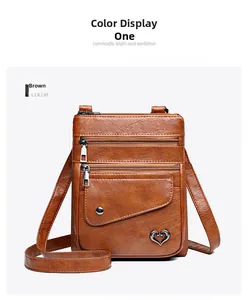 Close-up of brown PU leather crossbody bag with triple zippers and heart logo detail