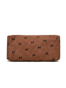 Detailed close-up of brown corduroy pouch with black bow print and quilted stitching