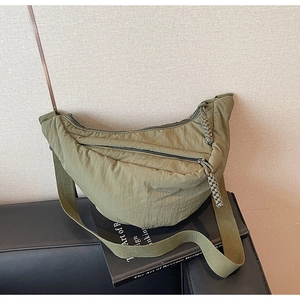 Dettaglio borsa a mezzaluna in nylon verde oliva con cerniera intrecciata e tracolla