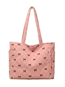 Detail of pink corduroy quilted tote bag with black bows and side pocket features