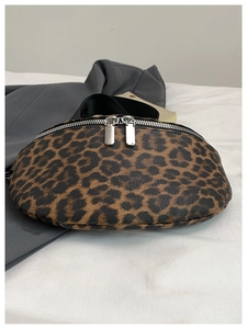 Détail du sac banane léopard avec doubles fermetures éclair argentées sur fond blanc