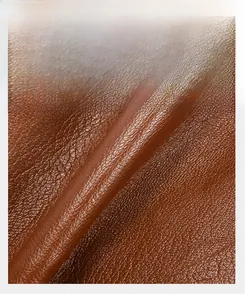 Detailed macro view of premium brown litchi grain soft leather material for crossbody bag