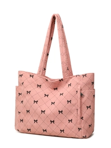 Pink corduroy tote bag detail showing black bow embroidery and side pocket compartment