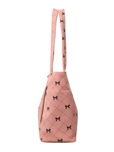 Close-up of pink corduroy tote bag featuring black bow patterns and diamond quilting