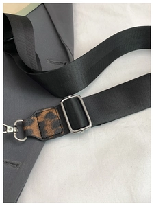 Gros plan détaillé de la sangle en nylon avec accent cuir léopard et boucle métal argent