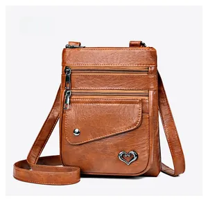 Micro side view of brown litchi pattern leather crossbody bag with zipper compartments