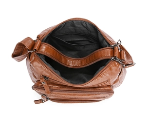 Top view of brown soft leather crossbody bag showing multi-compartment zipper storage