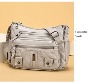 Detail view of large capacity crossbody bag featuring multi-zipper and quilted patterns