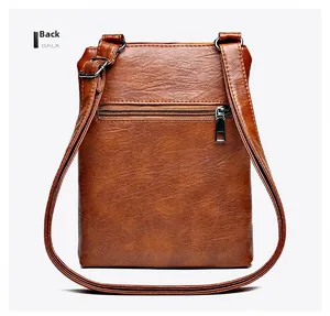 Detail view of the back zipper pocket on a brown vintage faux leather crossbody bag