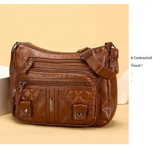 Detail of retro brown leather shoulder bag featuring quilted texture and zip pockets