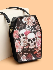 Detailed view of black coffin-shaped crossbody bag with skull and rose print and gold hardware