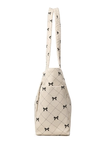 Detail of quilted corduroy tote bag showing soft texture and black bow print pattern