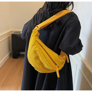 Dettaglio della borsa a tracolla gialla in nylon con trama a pieghe e tracolla larga