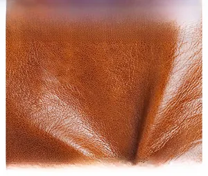 Close-up of brown litchi pattern leather texture with soft glossy finish on phone bag