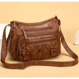 Close-up of brown washed leather crossbody bag with rhombic stitching and multi-zipper detail