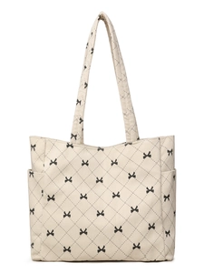 Detail of off-white corduroy tote bag with black quilted stitching and bow print pattern