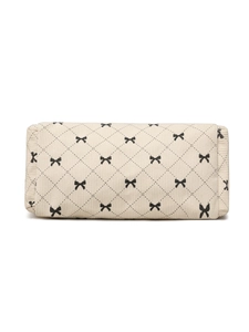 Detailed close-up of cream corduroy tote bag featuring quilted diamond pattern and black bows
