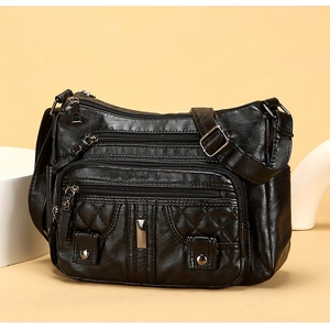 Close-up of black quilted PU leather shoulder bag with silver zippers and multi-pocket detail