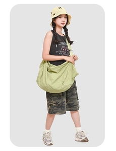 Detail of light green quilted hobo bag featuring water-resistant fabric and wide strap