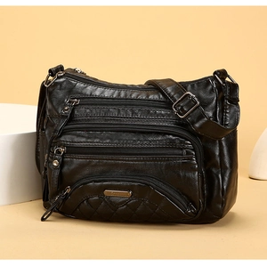 Detail view of soft black PU leather crossbody bag featuring multiple metal zipper pockets
