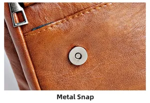 Close-up of silver magnetic metal clasp on brown lychee grain leather crossbody bag