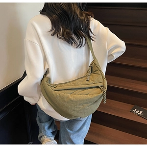 Dettaglio della borsa a tracolla trapuntata verde militare con zip in corda intrecciata