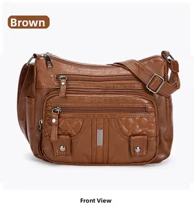 Detail of dark brown washed leather crossbody bag with multiple zippers and quilted texture