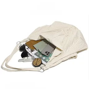 Detailed internal view showing large capacity and soft pleated texture of the beige tote bag