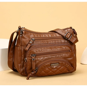 Detailed close-up of brown PU leather crossbody bag featuring multiple functional zippers