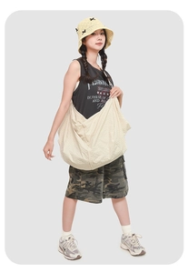 Detail of a large cream crossbody bag showing grid texture on model in street style