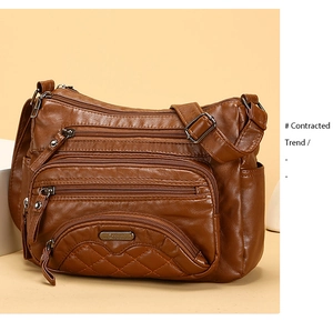 Detail view of brown vintage washed leather crossbody bag with multiple zippers