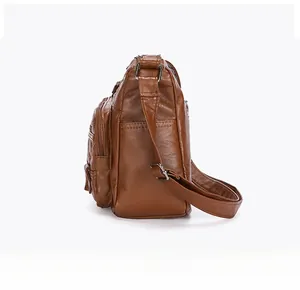 Side view of brown washed PU leather crossbody bag showing multiple zipper pockets