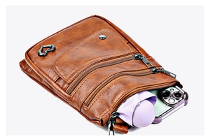 Detailed view of brown crossbody phone bag with multiple zippers showing interior storage