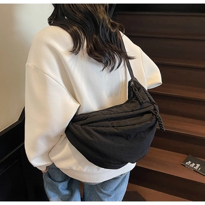 Dettaglio della borsa a mezzaluna in nylon nero con tirazip decorativo in corda intrecciata